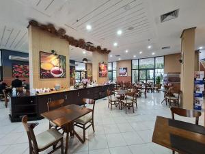 a restaurant with tables and chairs and a bar at Flat Tropical Hotel Vista Espetacular in Manaus