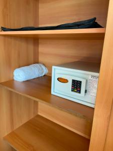 a microwave on a shelf in a closet at Flat Tropical Hotel Vista Espetacular in Manaus