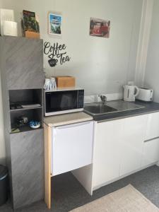 a small kitchen with a microwave and a sink at Cameo B&B in Matamata