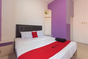 a bedroom with a large bed with a red blanket at RedDoorz Plus @ Tuparev Cirebon 2 in Cirebon