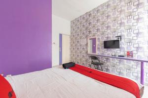 a bedroom with a bed and a tv on a wall at RedDoorz Plus @ Tuparev Cirebon 2 in Cirebon