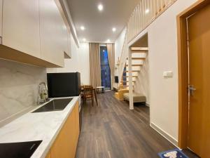 a kitchen with a sink and a living room at Sun Uban City Hà Nam in Quang Ãm