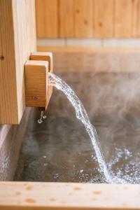 a stream of water coming out of a water fountain at 源泉かけ流し温泉貸切別荘 霧島のテラス in Kirishima +107 photos