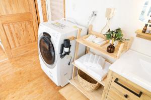 a washing machine in a room with a sink at 源泉かけ流し温泉貸切別荘 霧島のテラス in Kirishima