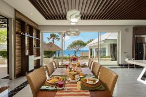 a dining room with a table with food on it at Pandawa Cliff Ocean view with private beach in Nusa Dua
