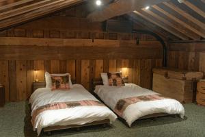 two beds in a room with wooden walls at ISEZI Private Estate in Shibata