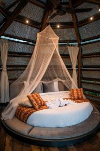 a bed in a room with a mosquito net at Ant House Sidemen in Silebeng
