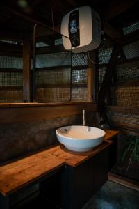 a bathroom with a white sink on a wooden counter at Ant House Sidemen in Silebeng +8 photos