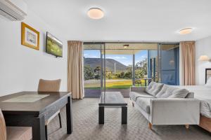 a living room with a bed and a couch and a table at Lufra Beachside Hotel in Eaglehawk Neck