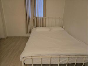 a bed with white sheets and pillows in a room at 지슬스테이 in Pyoseon