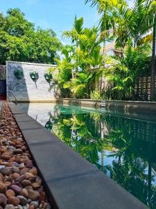 a pool in the backyard of a house with a tropical garden at Bou Savy Guesthouse in Siem Reap