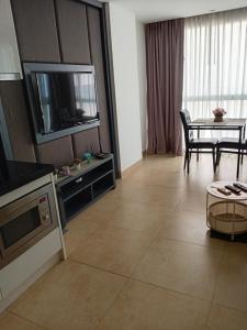 a living room with a television and a table with chairs at Central Pattaya Apartments in Pattaya