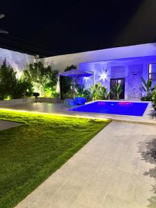 a backyard at night with a swimming pool at شاليهات دبليو العمارية W Chalet in Al ‘Ammārīyah