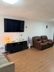 a living room with a couch and a flat screen tv at Las Minervas in Monterrey +8 photos