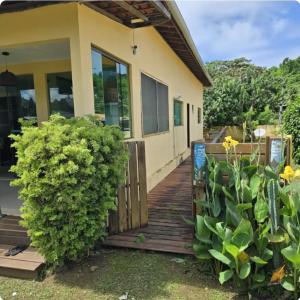 a house with a wooden walkway in front of it at Quarto privativo Pousada Luna in Fernando de Noronha