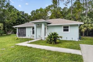 a white house with a green yard at Abi's House - Private Jupiter Escape in Jupiter