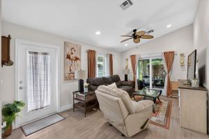 a living room with a couch and a ceiling fan at Abi's House - Private Jupiter Escape in Jupiter
