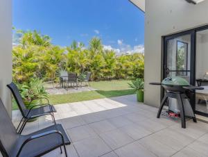 a patio with a grill and a table and chairs at Longboard Coastal Retreat in Kingscliff
