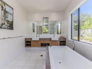 a bathroom with two sinks and a large mirror at Longboard Coastal Retreat in Kingscliff +31 photos