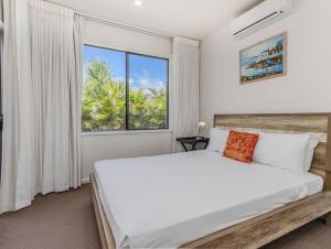 a bedroom with a large bed and a window at Longboard Coastal Retreat in Kingscliff