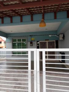 a building with a white fence in front of it at D Aida Homestay Bukit Katil in Kampong Bukit Katil