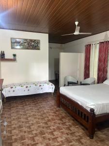 a bedroom with two beds and a table and chairs at Hasiru Homestay in Mudigere