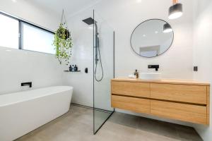 a bathroom with a tub and a sink and a mirror at Driftaway, Albany in Albany