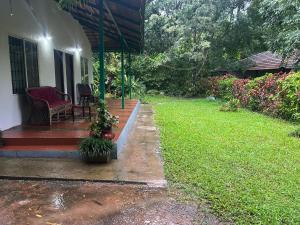 a porch of a house with a chair and a yard at Hasiru Homestay in Mudigere +8 photos