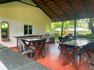 a patio with tables and chairs in a room at Hasiru Homestay in Mudigere
