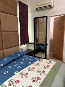 a bedroom with a bed with a blue comforter at D Aida Homestay Bukit Katil in Kampong Bukit Katil