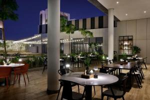 a restaurant with tables and chairs at night at Sheraton Bahrain Hotel in Manama