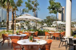 an outdoor dining area with tables and chairs and umbrellas at Sheraton Bahrain Hotel in Manama