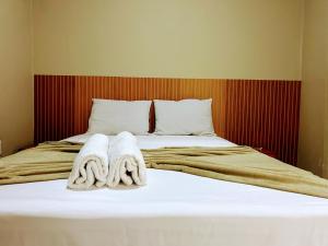 a bed with towels on top of it at Recanto Sole Luz in Piranhas