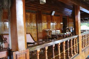 - une rangée de chaises dans une chambre dotée de murs en bois dans l'établissement Malayalam Lake Resort, à Alappuzha