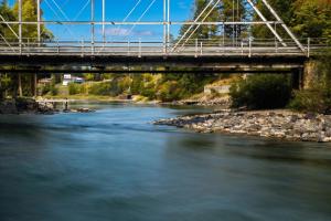 a bridge over a river with rocks at The Cottages at Bigfork in Bigfork