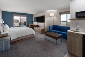 a hotel room with a bed and a blue couch at Holiday Inn Express Rawlins by IHG in Rawlins