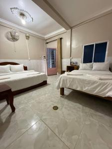 a large bedroom with two beds and a large tile floor at Koh Rong Homestay in Kaôh Rŭng (3)