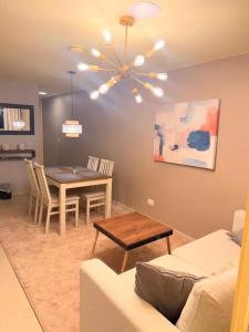 a living room with a dining room table and a chandelier at Sky Luxury Suites in Bucaramanga +15 photos
