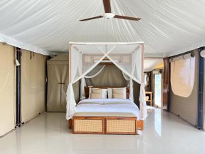 a bedroom with a canopy bed in a tent at The Agung & Sunset Tent by BaliSuperHost in Nusa Penida