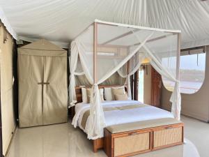 a bedroom with a canopy bed in a tent at The Agung & Sunset Tent by BaliSuperHost in Nusa Penida