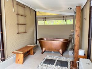 a bathroom with a copper tub and a sink at The Agung & Sunset Tent by BaliSuperHost in Nusa Penida
