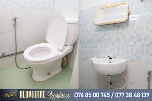 a bathroom with a toilet and a sink at Aluvihare Residence in Matale