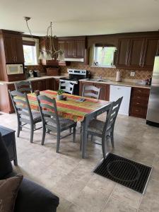 a kitchen with a table and chairs in a kitchen at maison chez René in Saint-Malachie