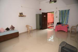 a room with a bed and a table and chairs at Gennys Farm House in Sawantwadi