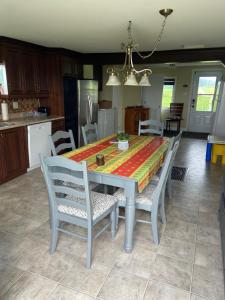 a dining room table with chairs and a kitchen at maison chez René in Saint-Malachie +8 photos