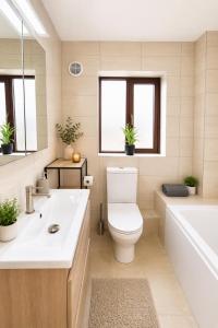 a bathroom with a toilet and a tub and a sink at Ardee Retreat - Sleeps 6, Garden, Walk to Town in Ardee