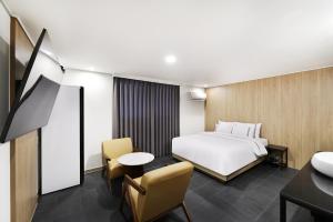 a hotel room with a bed and a table and chair at 서천 마리 호텔 in Seocheon