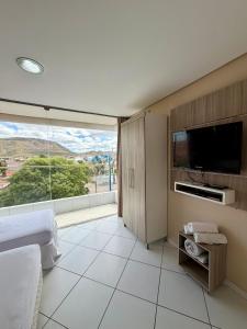 a bedroom with a tv and a large window at Prado Hotel in Salgueiro