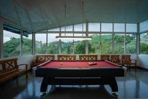 a room with a pool table in a room with windows at Falcon Crest in Vagamon