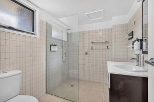 a bathroom with a shower and a toilet and a sink at Lufra Beachside Hotel in Eaglehawk Neck